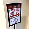 Sign with right facing arrow pointing to entrance of the Learning Center.
