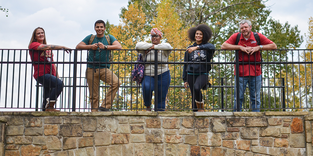 Students standing against the railing of the Timberwolf Trail bridge.