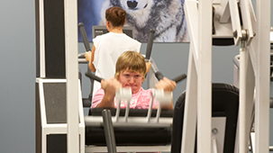 Students using equipment to work out his arms.