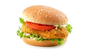 Chicken sandwich featuring tomatoes, ranch, and lettuce.